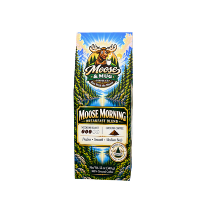Moose Morning medium roast ground coffee with a steaming mug in a coffee product setting